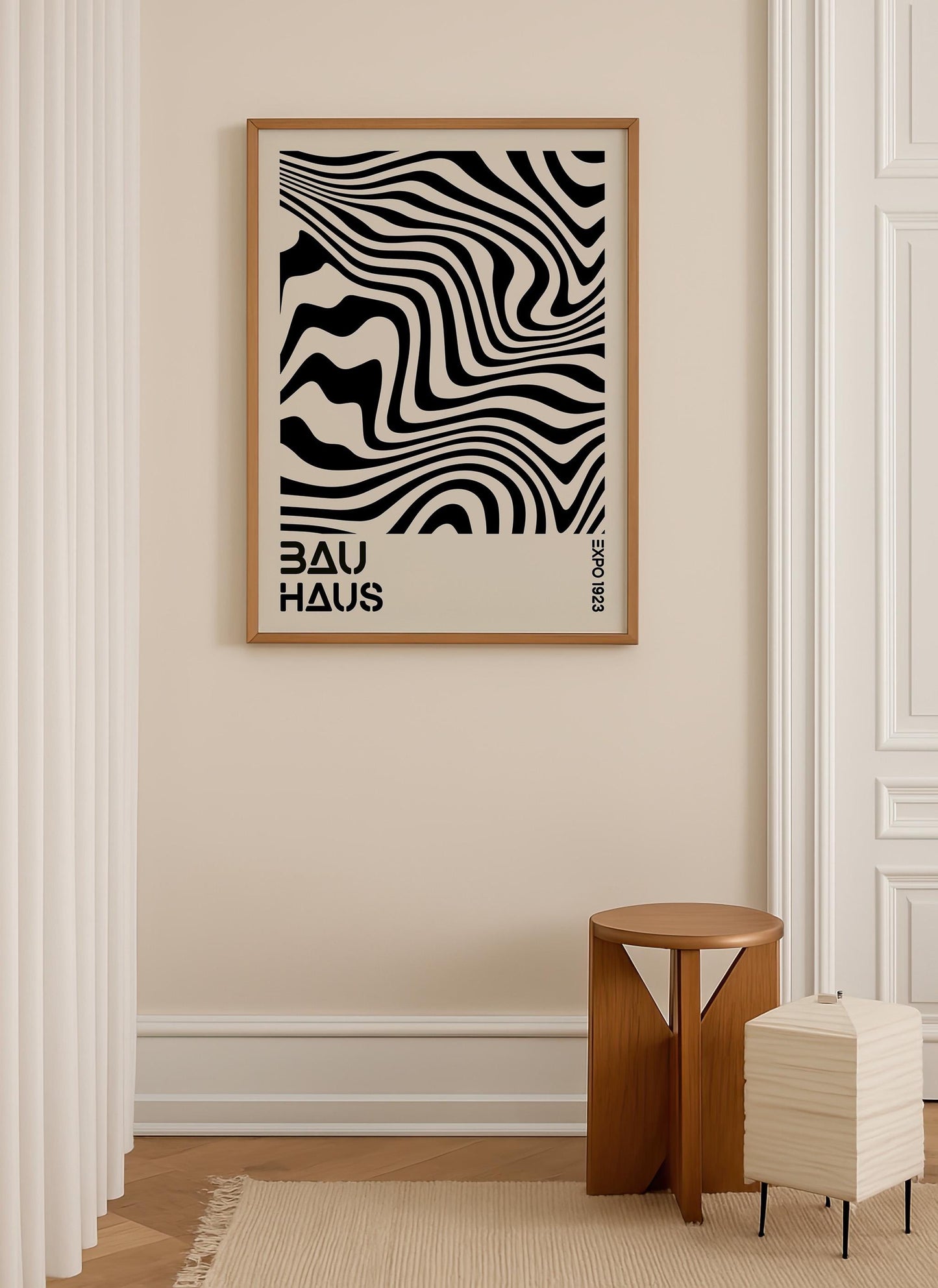 a minimalist interior design with a framed poster of a black and white zigzag pattern hanging on a beige wall. Below the poster, there is a small wooden stool and a white lamp.
