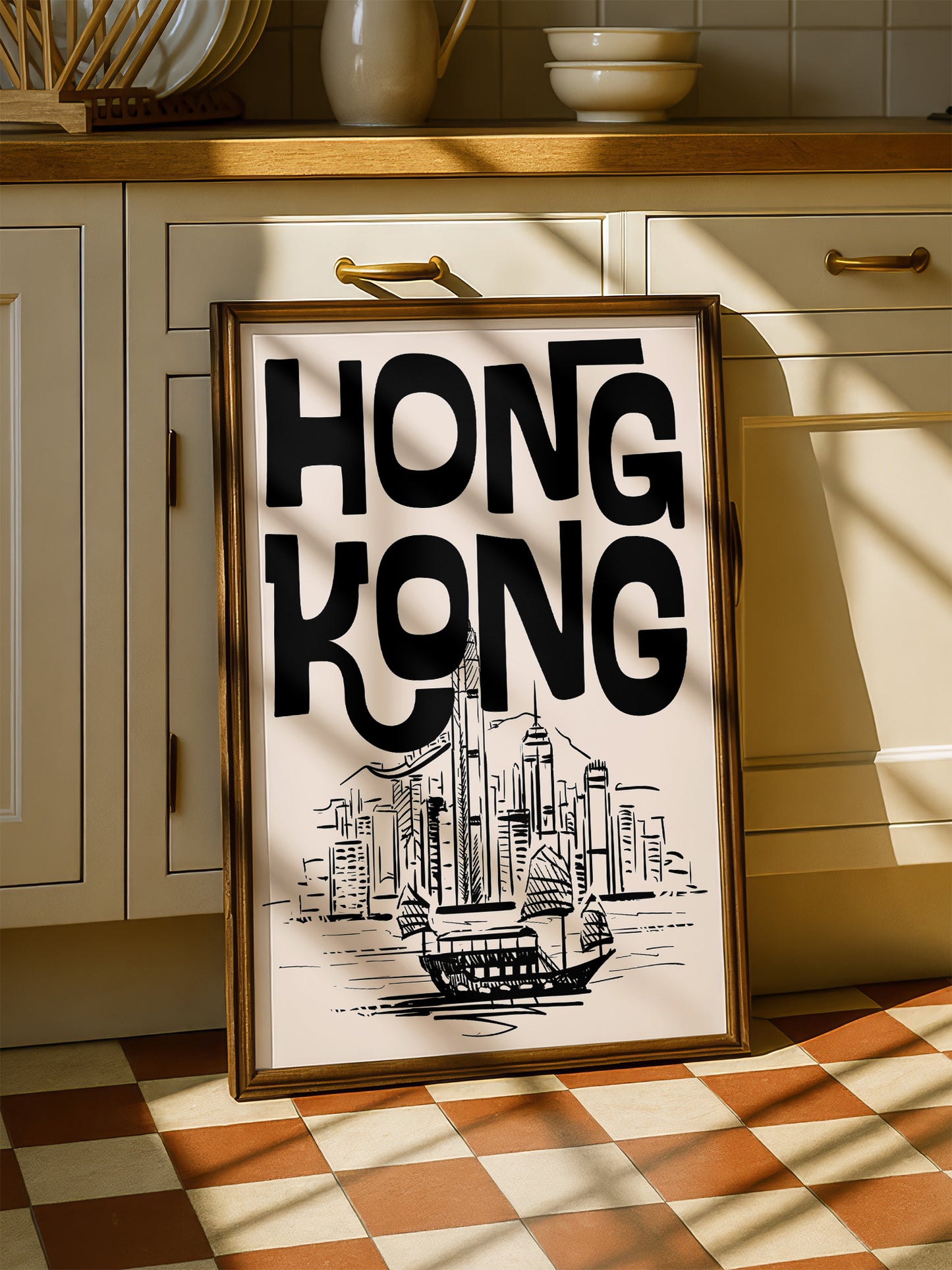 A framed poster with the text "HONG KONG" prominently displayed, featuring an illustration of Hong Kong's skyline.