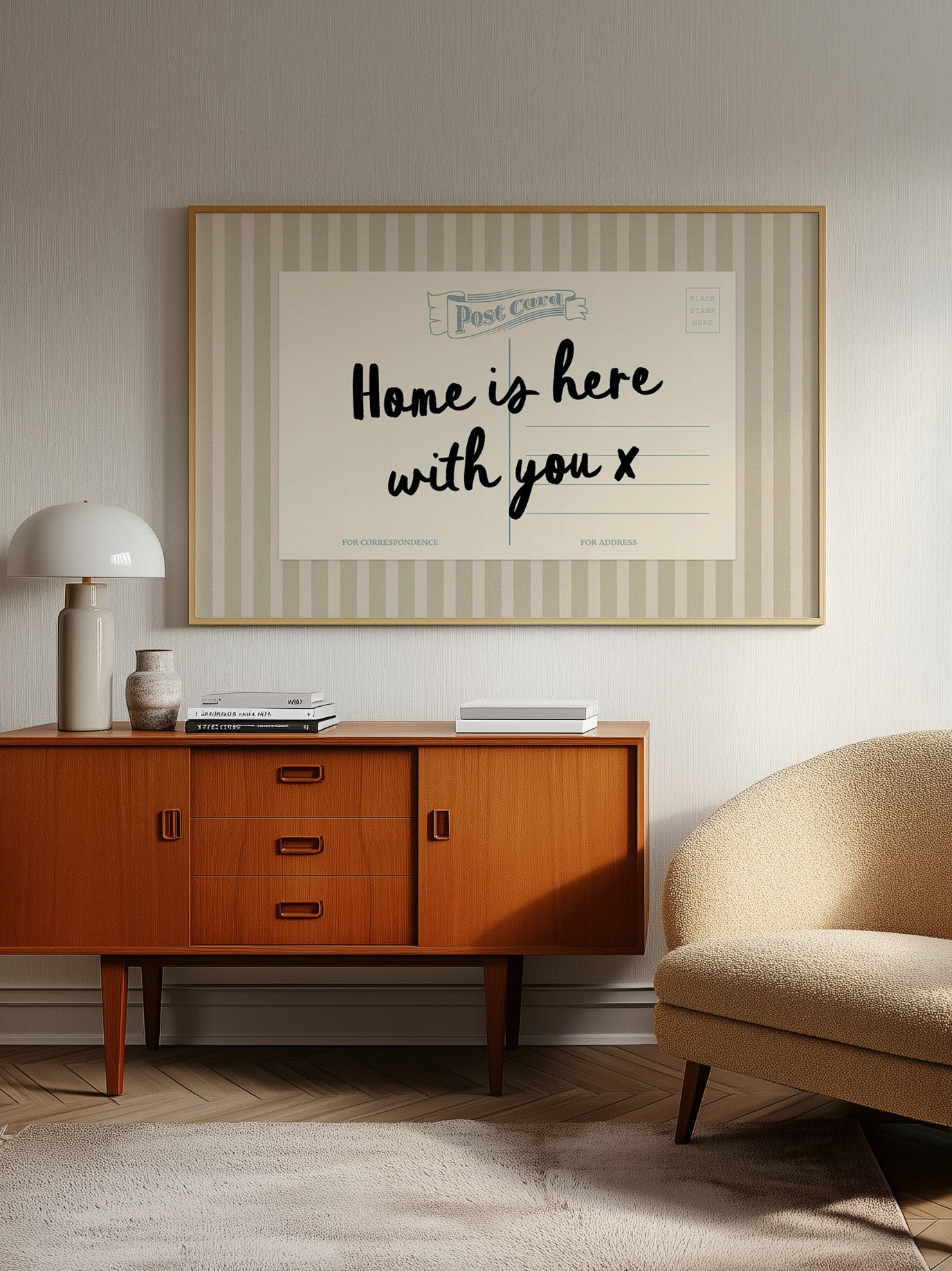 a cozy living room with a wooden cabinet, a beige armchair, and a framed poster on the wall that reads "Home is here with you x".