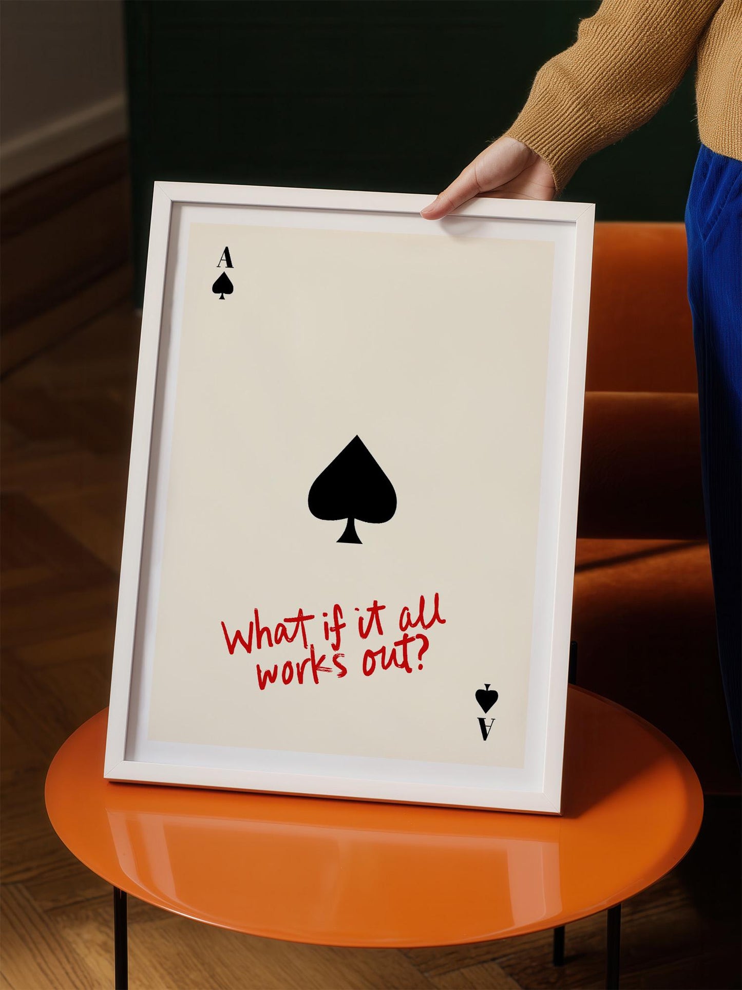 A person is holding a framed print with a question written on it, which appears to be a creative or artistic expression.