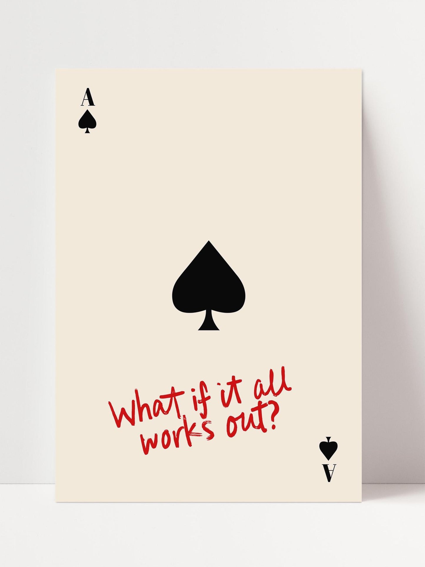 The image is a simple, minimalist design featuring a black spade symbol on a beige background, accompanied by the question "What if it all works out?" in red text.