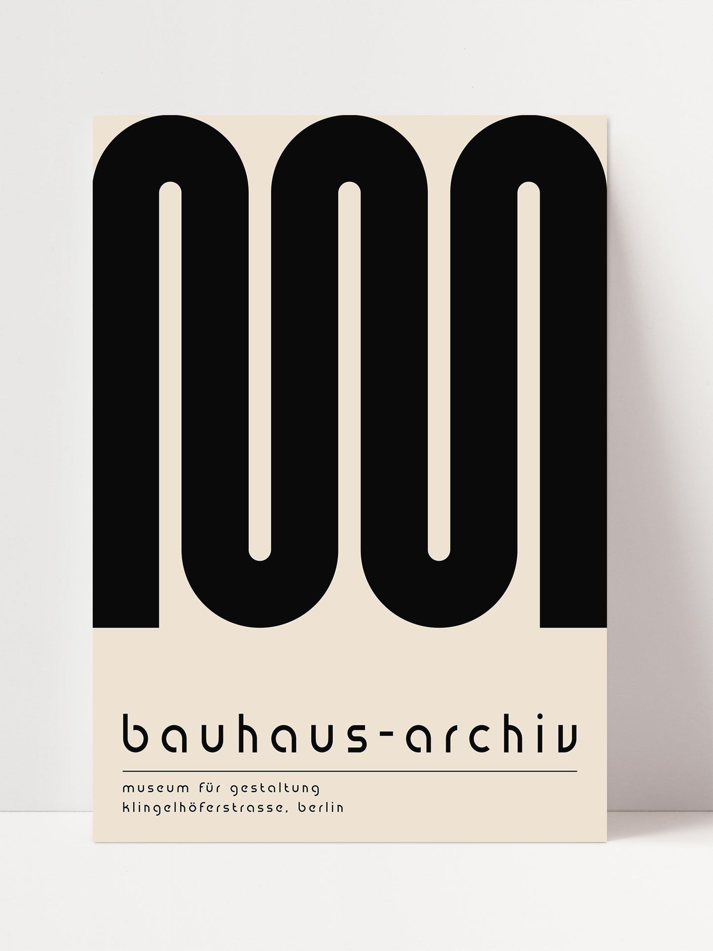 The image is a poster for the Bauhaus-archiv in Berlin, featuring a minimalist design with a large black letter "M" and text below it.