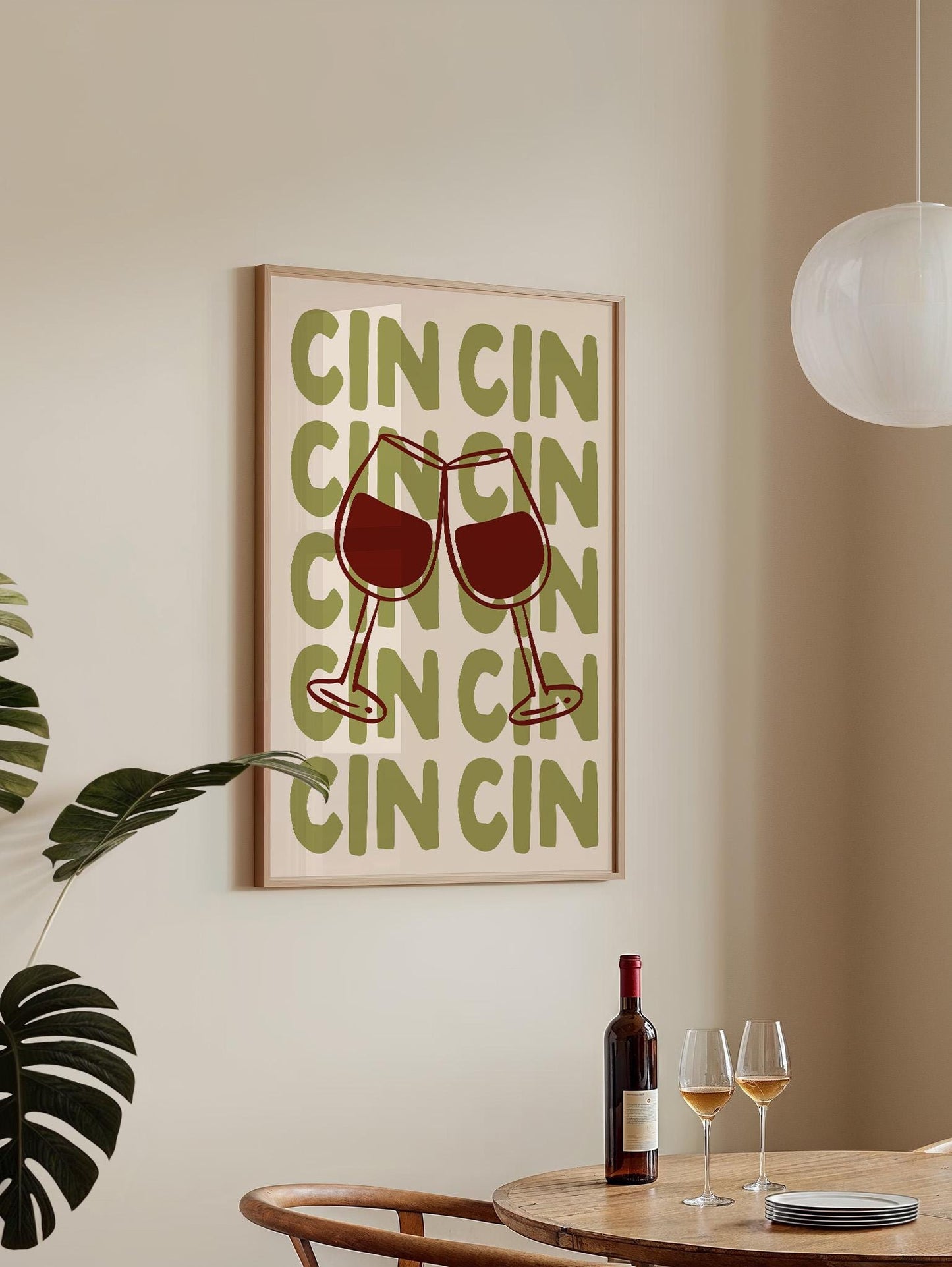 a framed poster with the word "CINCI" repeated in a stylized font, along with wine glasses and a bottle of wine on a table.