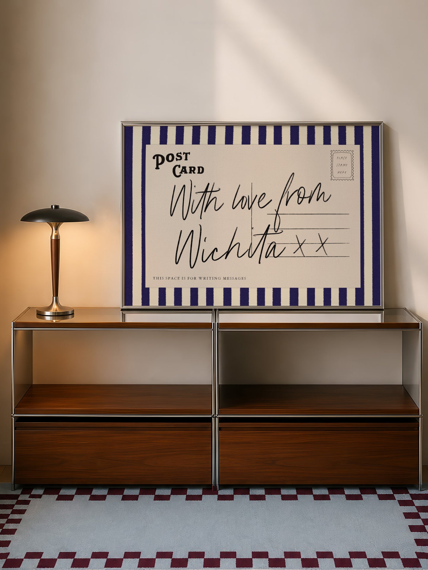 a wooden cabinet with a lamp on top, and a framed postcard with a handwritten message is displayed on the cabinet.