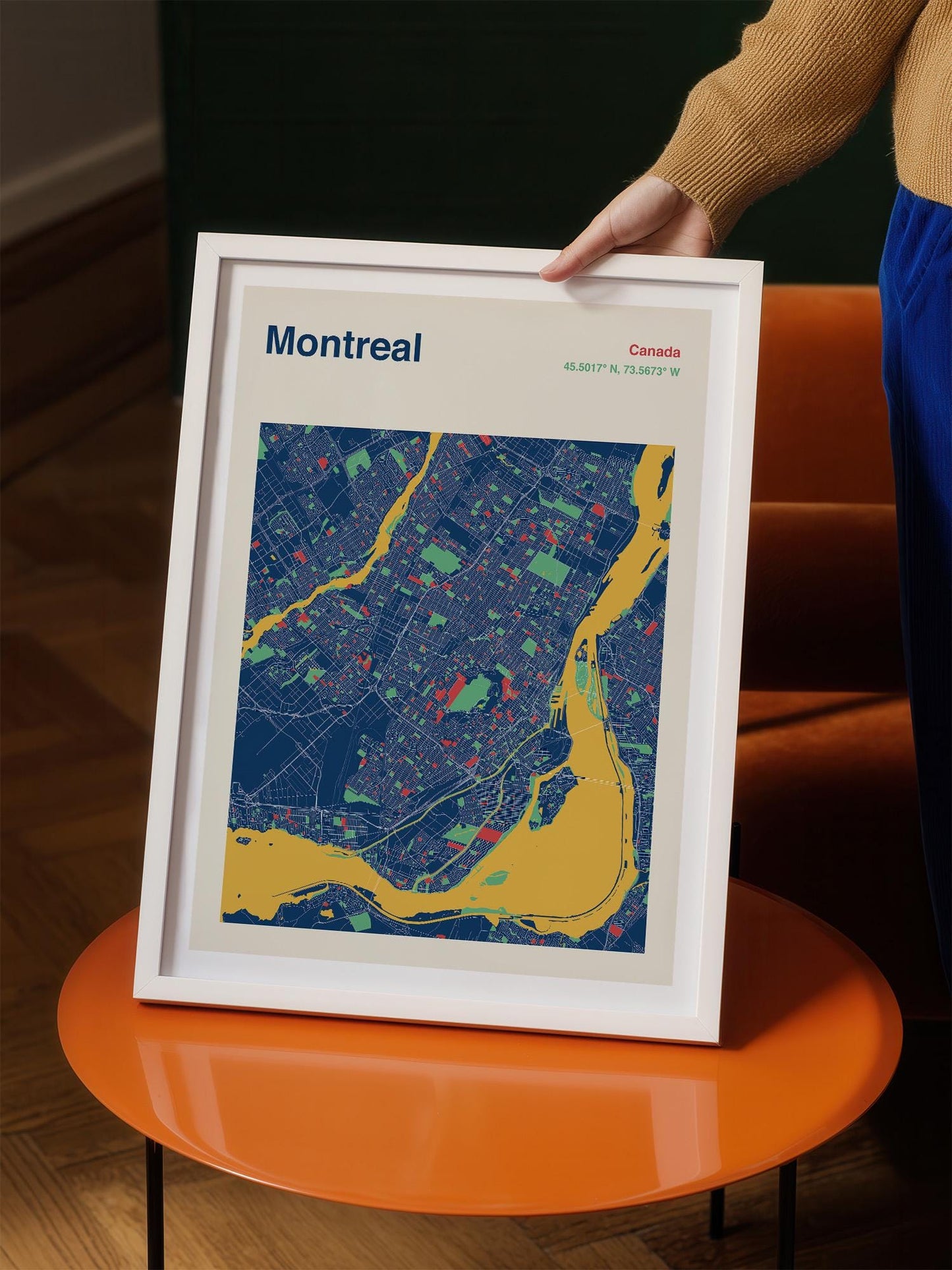 A person is holding a framed map of Montreal, Canada, which features a colorful and detailed representation of the city.