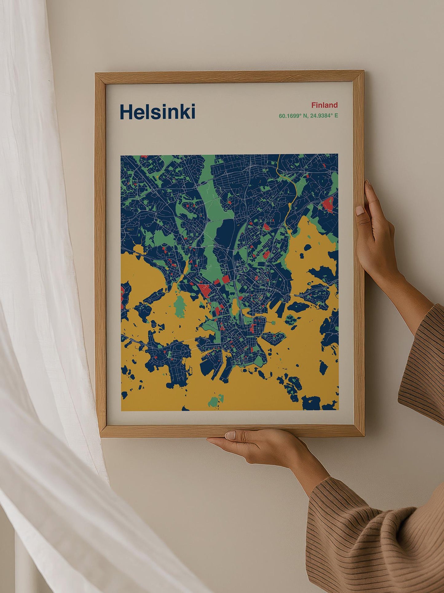 A person is holding up a framed map of Helsinki, Finland.