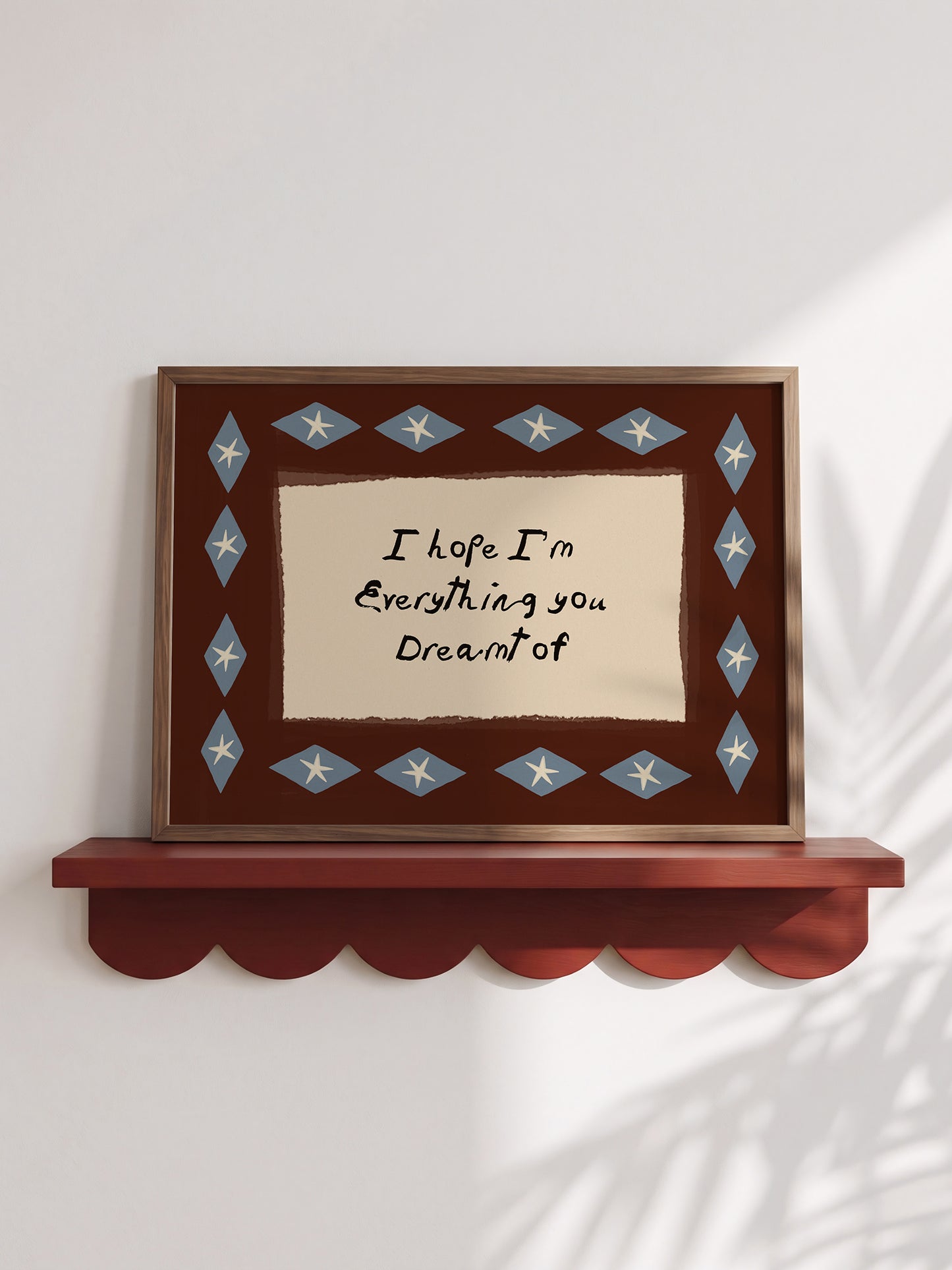 a framed picture with a message on it, placed on a shelf against a white wall.