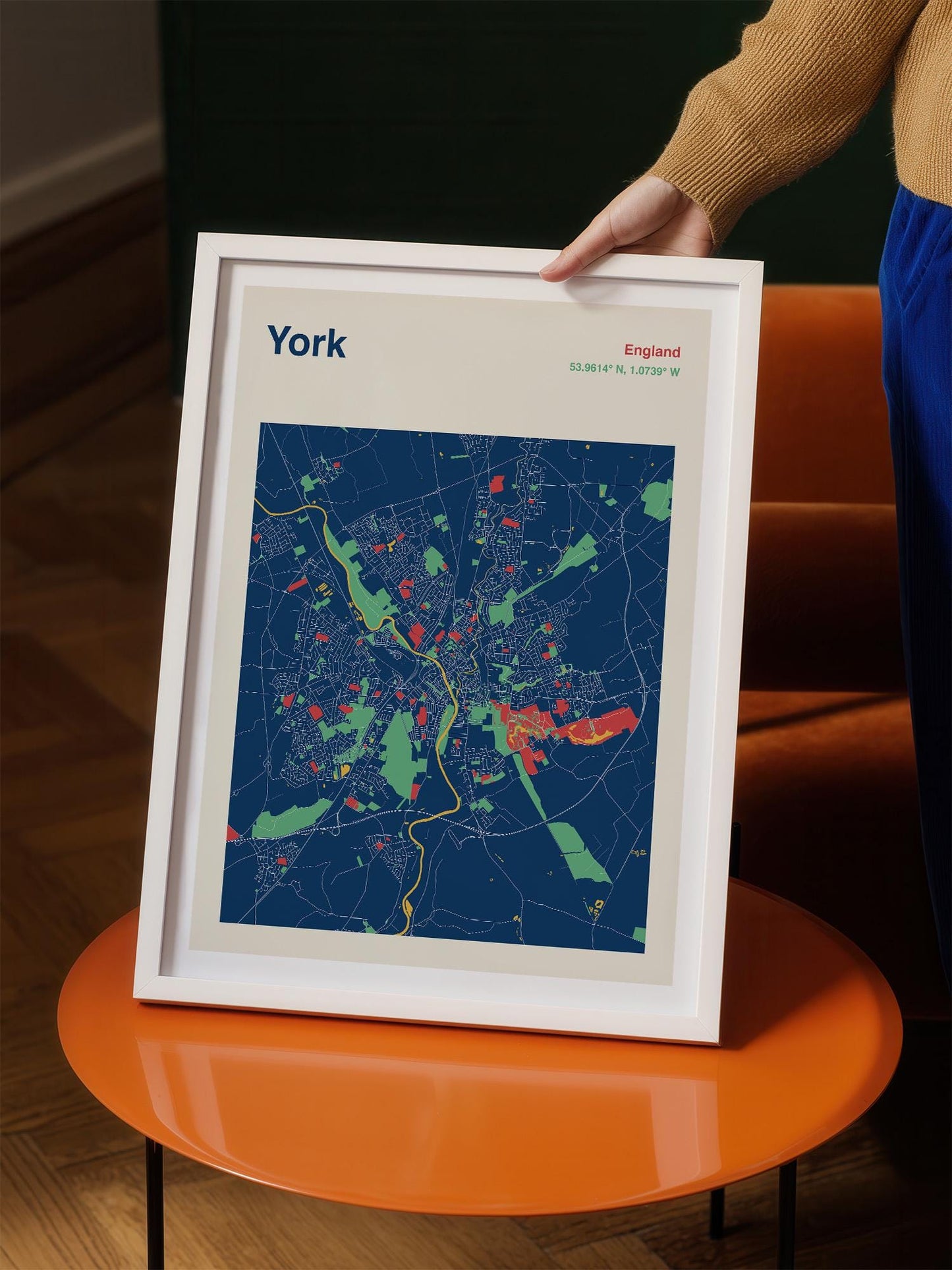 A person is holding a framed map of York, England, with a colorful and detailed representation of the city's streets and landmarks.