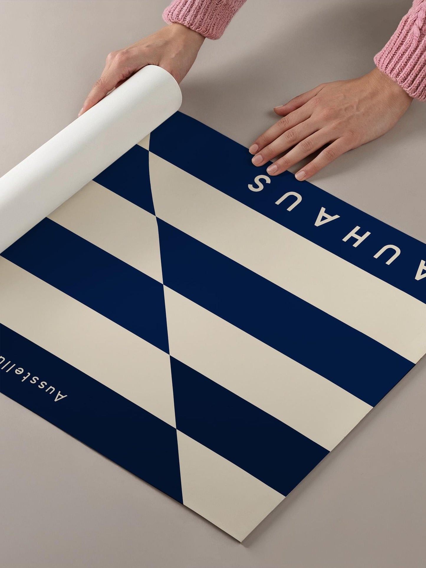 A person's hands are holding a roll of paper with a blue and white striped pattern on it.