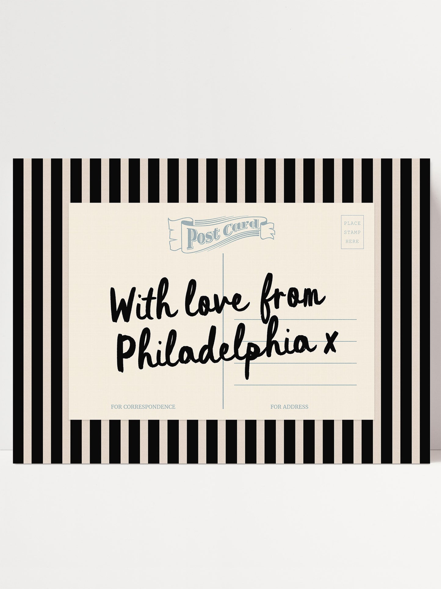 A postcard with a black and white striped border and handwritten text that reads "With love from Philadelphia x".