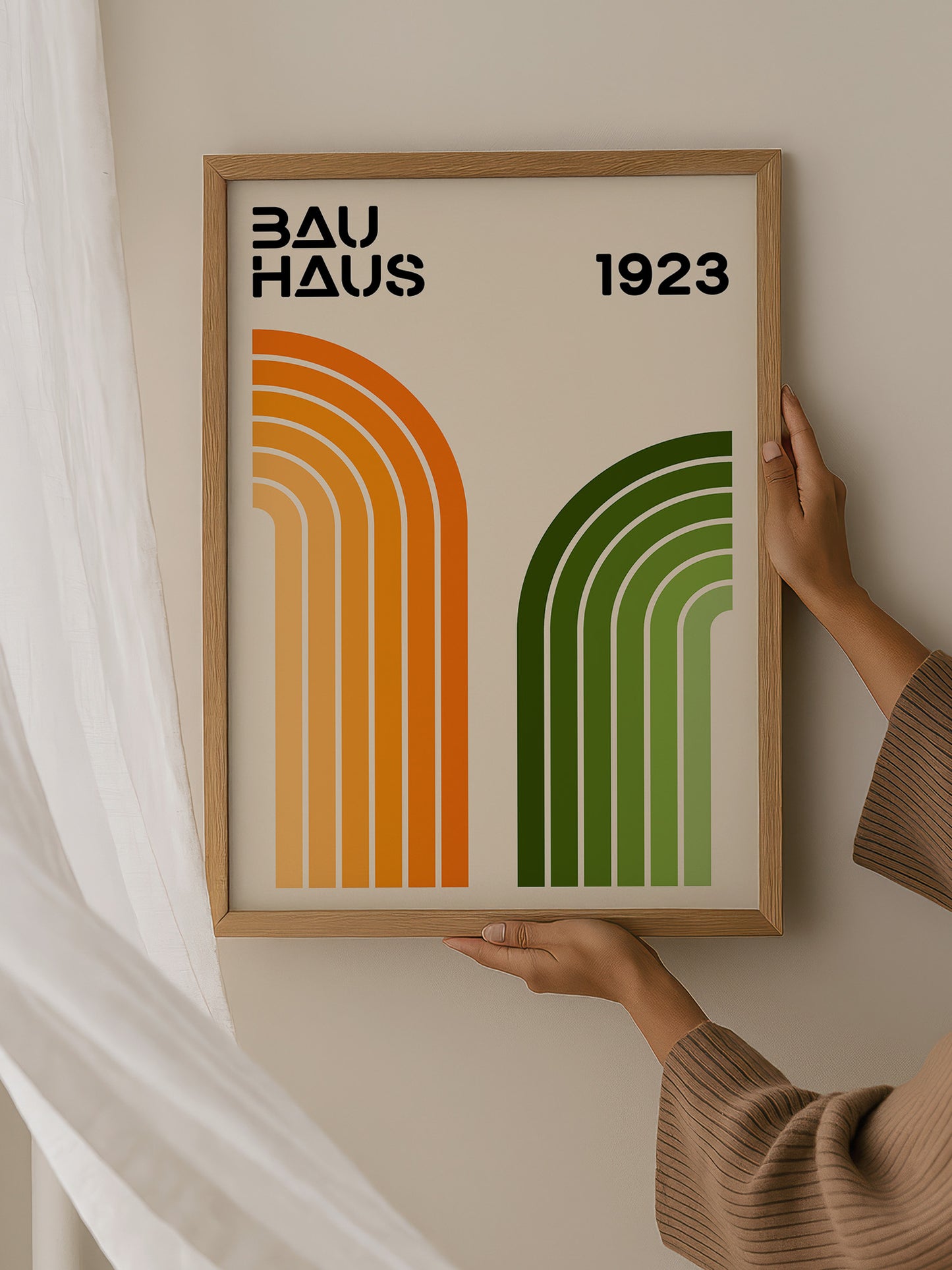 A person is holding up a framed poster with the text "BAU HAUS 1923" on it.