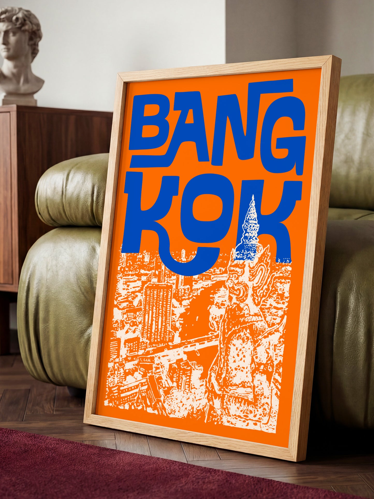a framed poster with the word "BANG KOK" prominently displayed in large blue letters, along with an illustration of a cityscape.