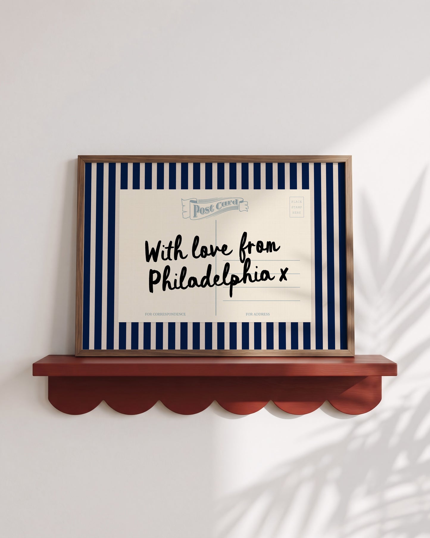 A framed postcard with a blue and white striped border, featuring a handwritten message that reads "With love from Philadelphia x" and "FOR ADDRESS".