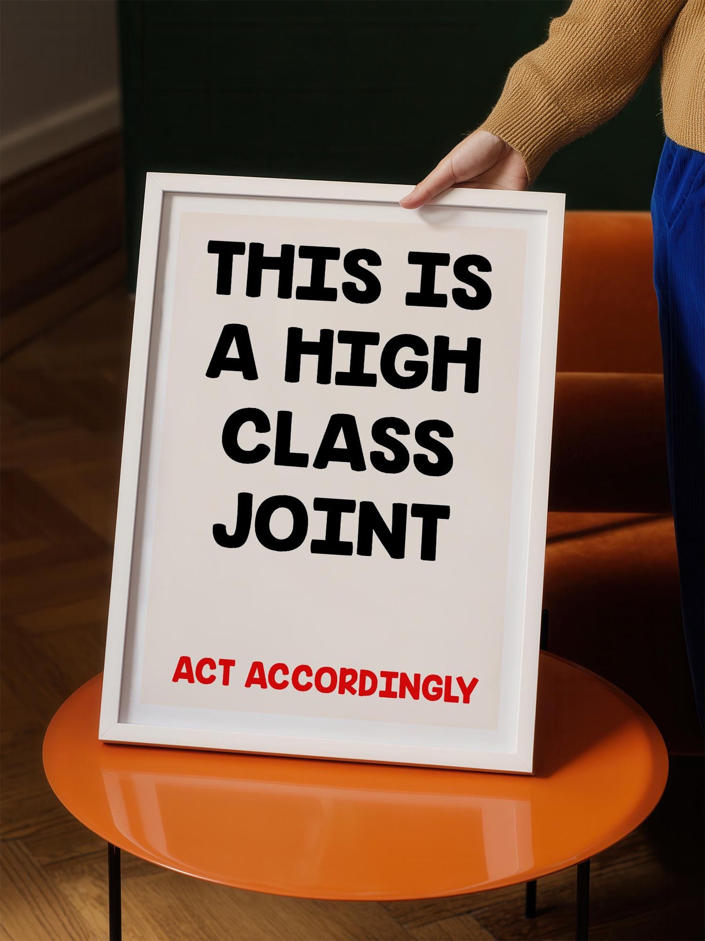 a person holding a framed sign with the text "THIS IS A HIGH CLASS JOINT ACT ACCORDINGLY" written on it.