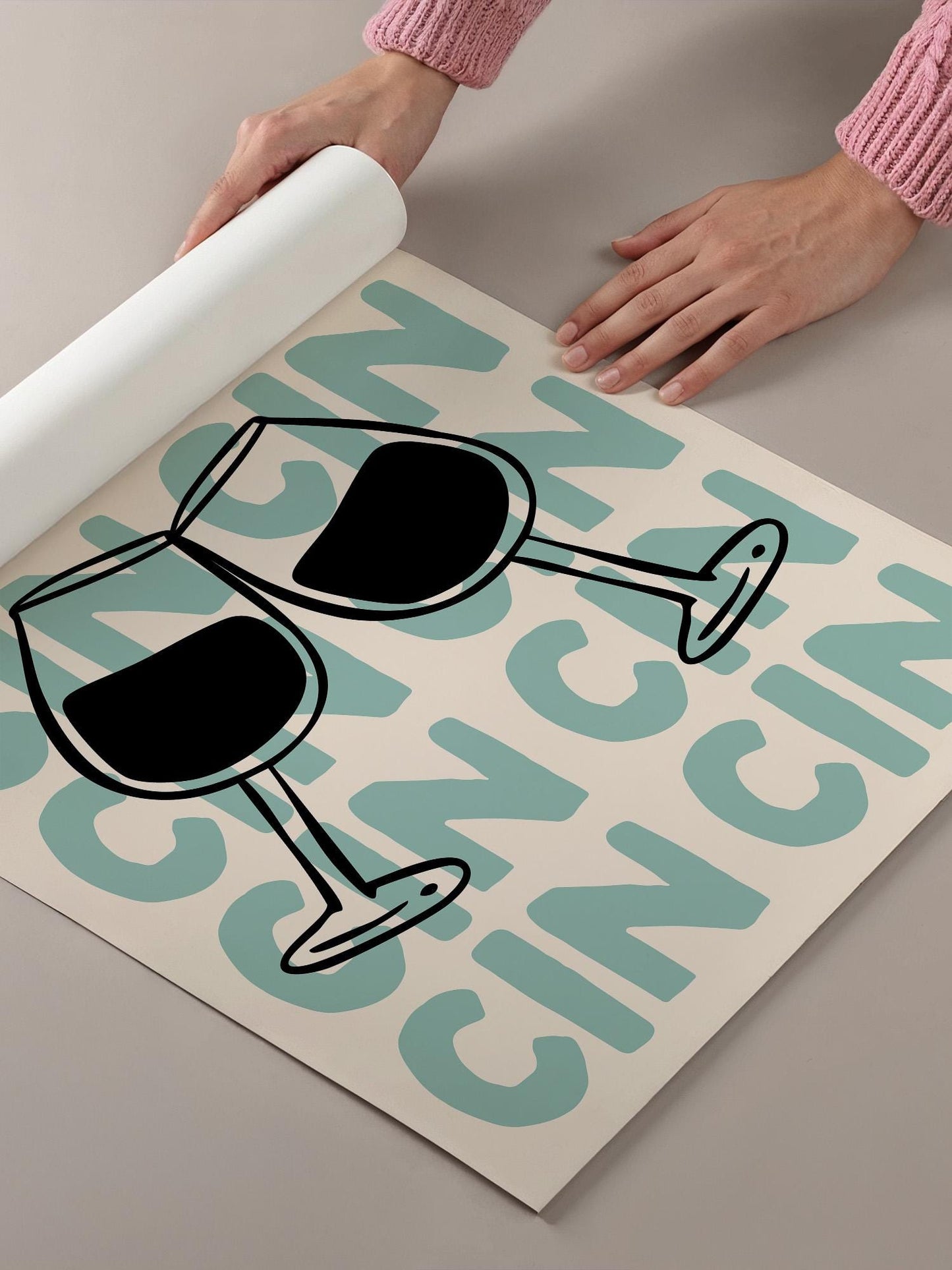 a person's hands holding a roll of paper, with a poster or sign featuring a wine glass and the word "CINNAMON" written on it.