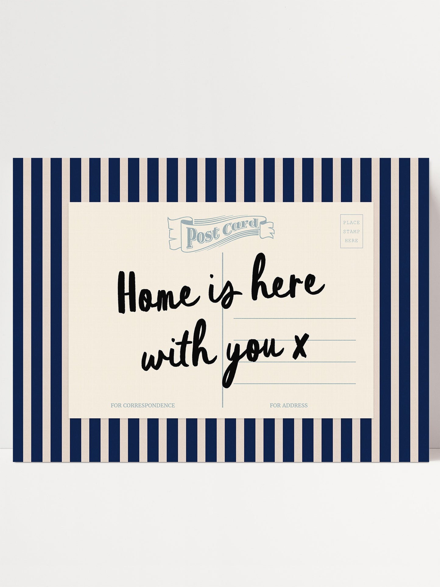 A postcard with a blue and white striped border, featuring the text "Home is here with you x" in a handwritten style.