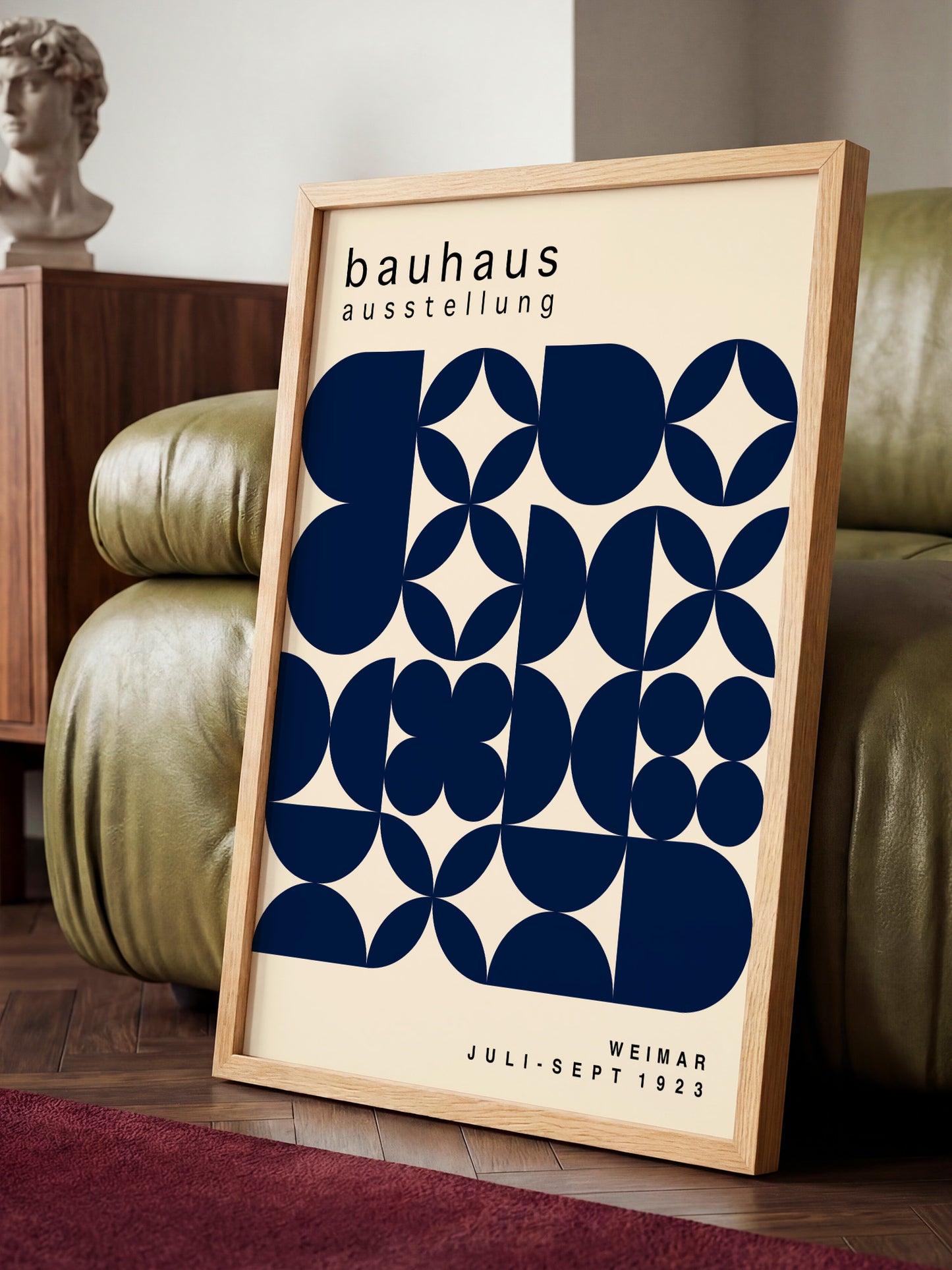 a framed poster of the Bauhaus art school, displaying a geometric design in shades of blue and white.