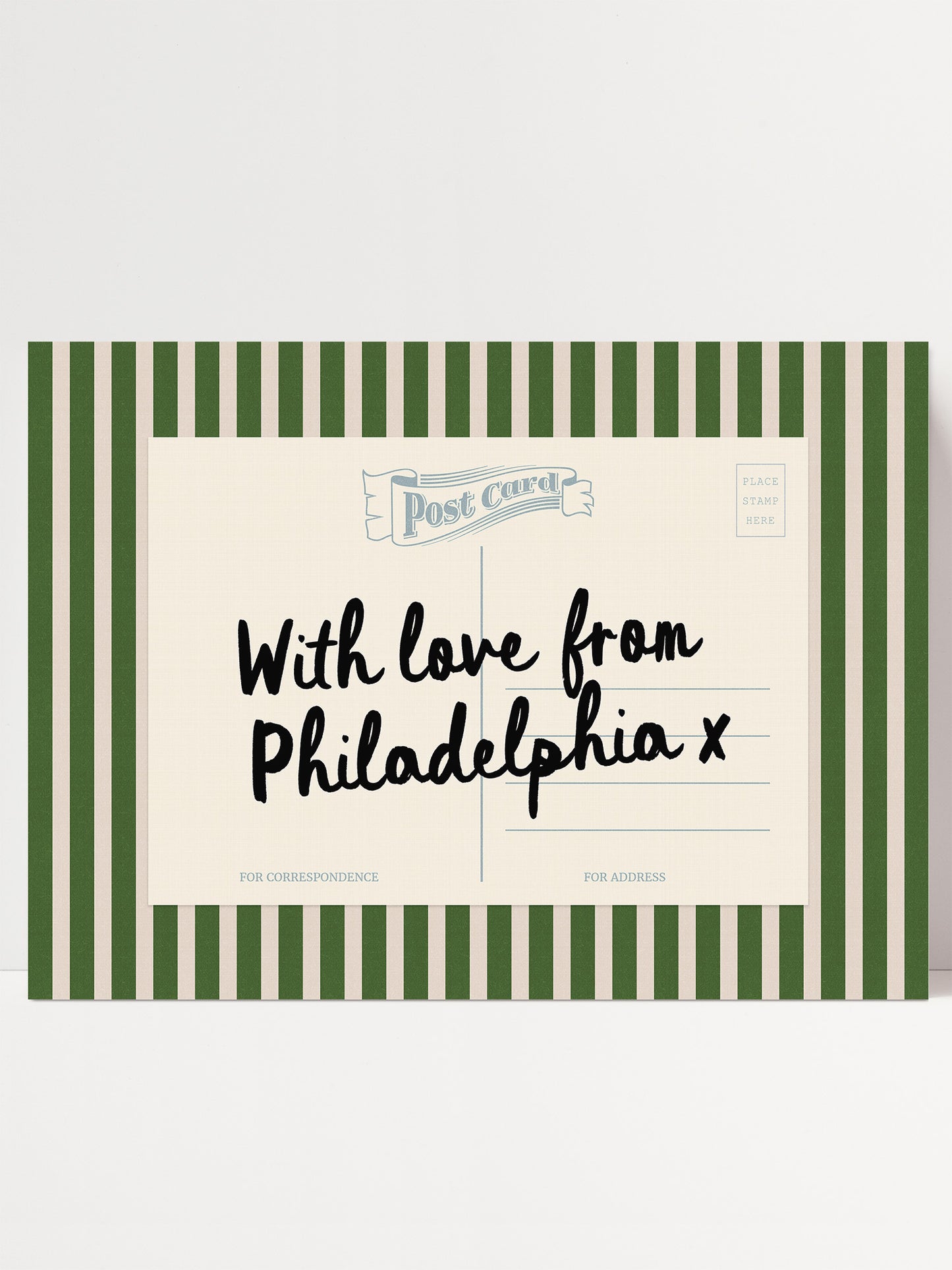 A green and white striped postcard with handwritten text on it.