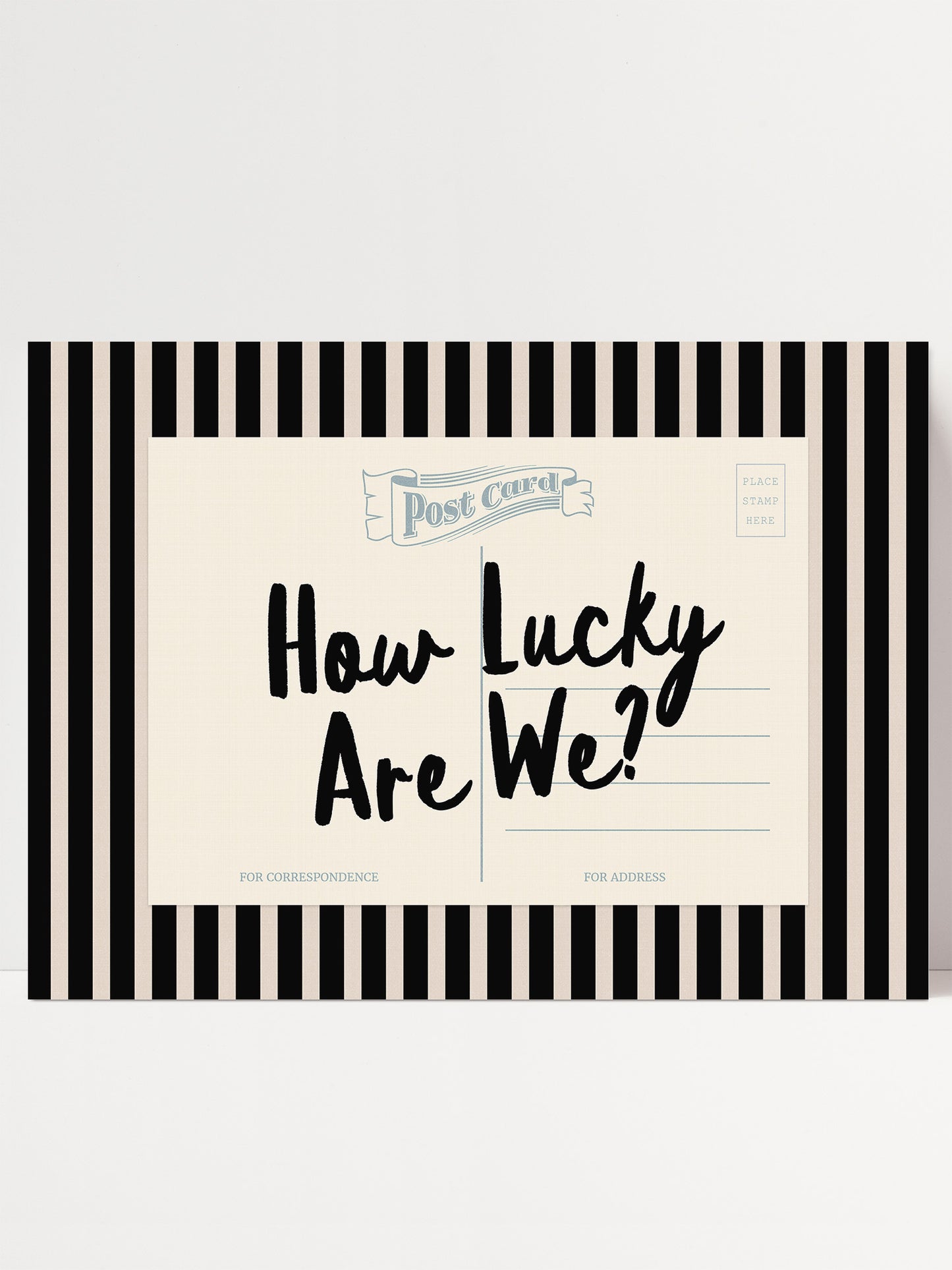 A postcard with a black and white striped border and the text "How Lucky Are We?" written on it.