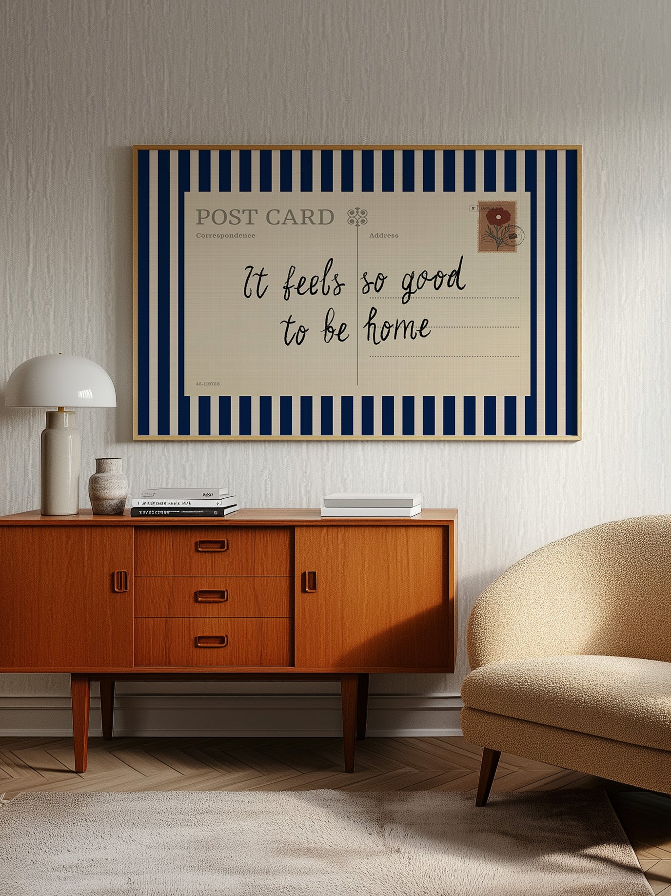 a vintage-style wooden cabinet with a blue and white striped frame, a lamp, a sofa, and a framed postcard with a handwritten message.