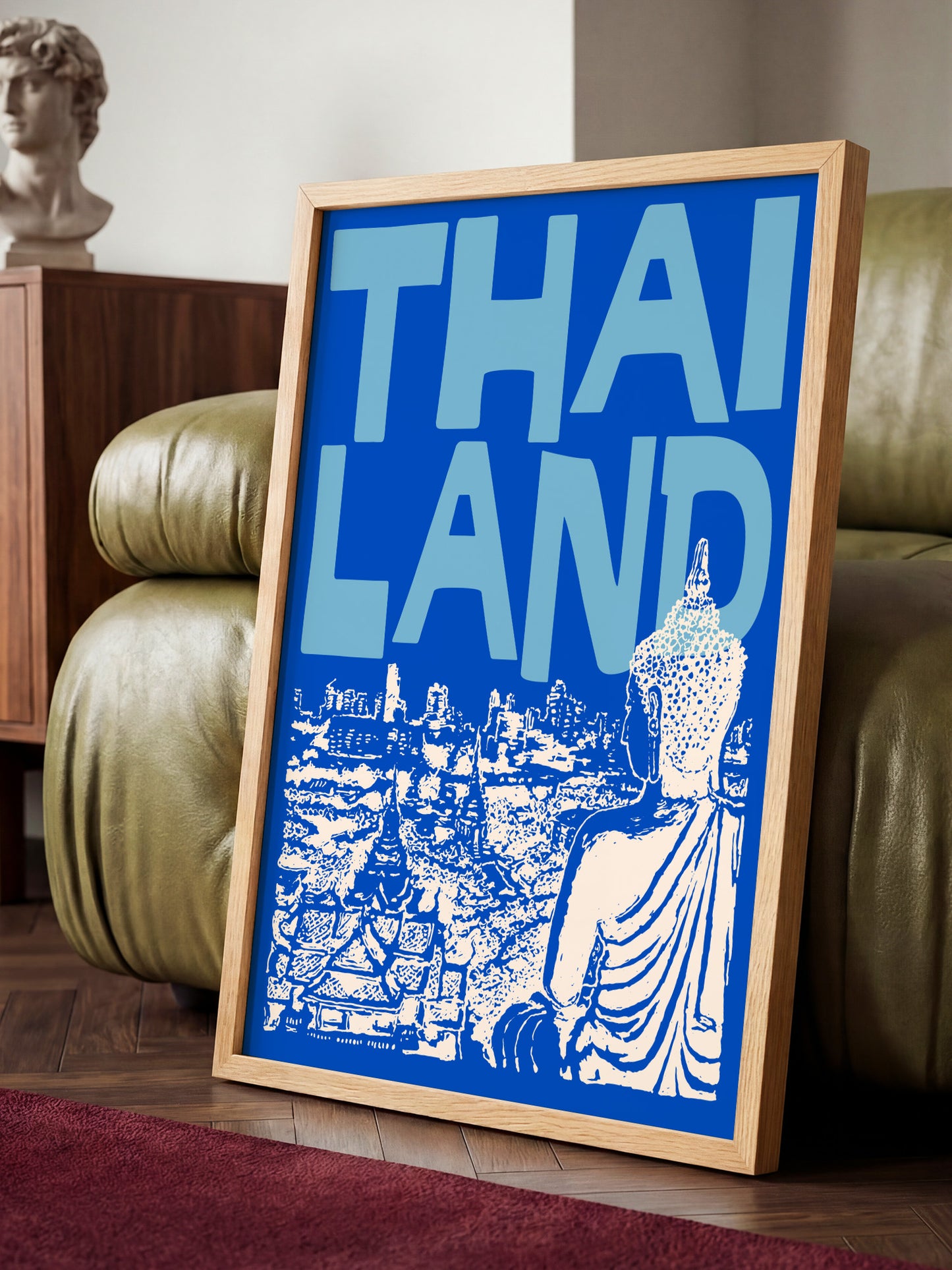 A framed poster with the text "THAI LANDS" displayed prominently in the center, featuring an illustration of a Buddha statue and a cityscape.