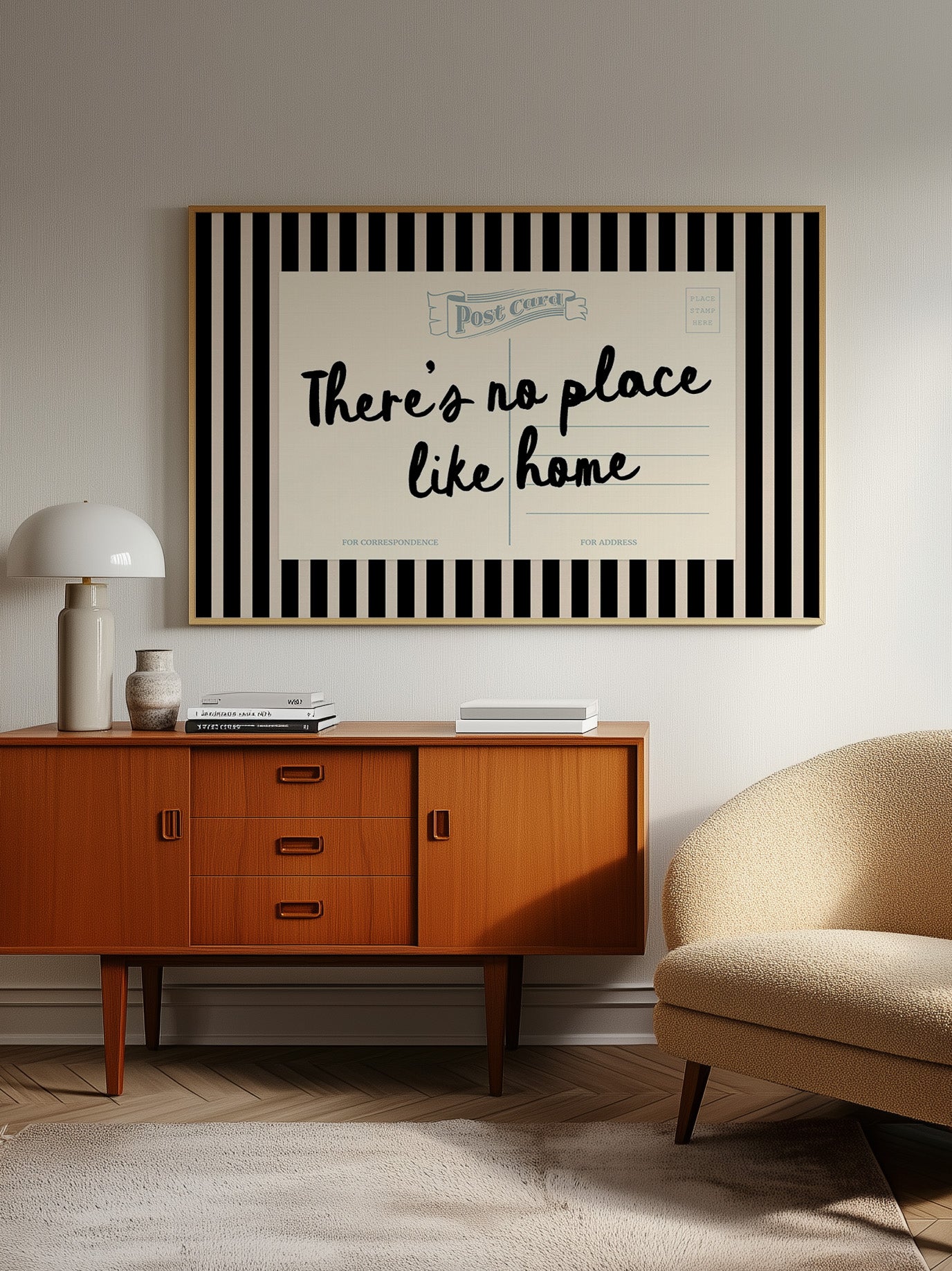 a vintage-style wooden cabinet with a lamp, a beige armchair, and a framed poster with the text "There's no place like home" on the wall above the cabinet.