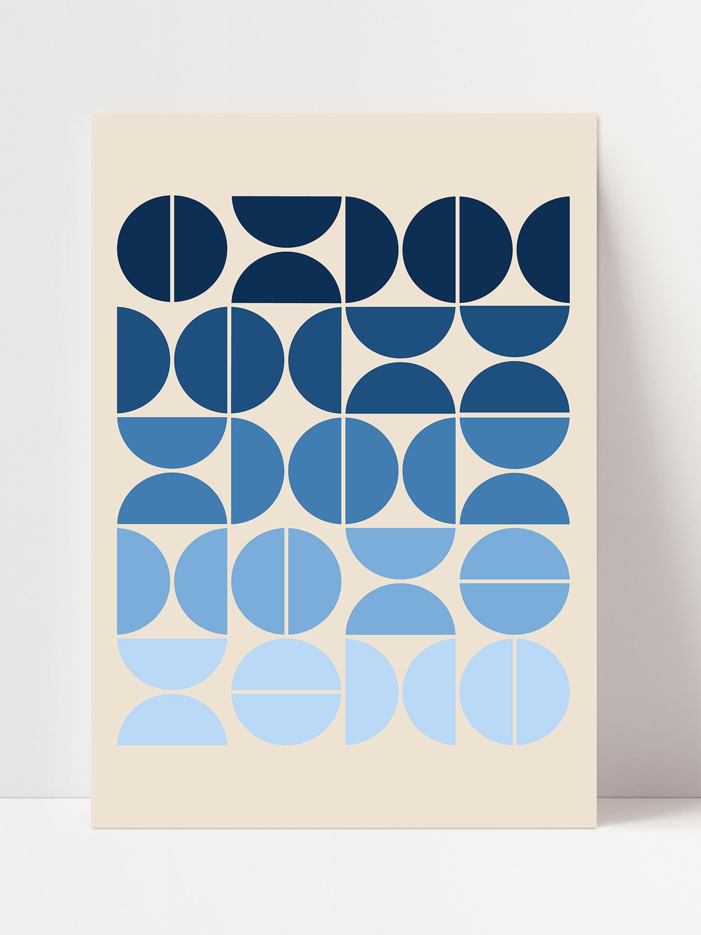 The image is a minimalist art piece featuring a repeating pattern of blue and white circles and ovals on a light beige background.