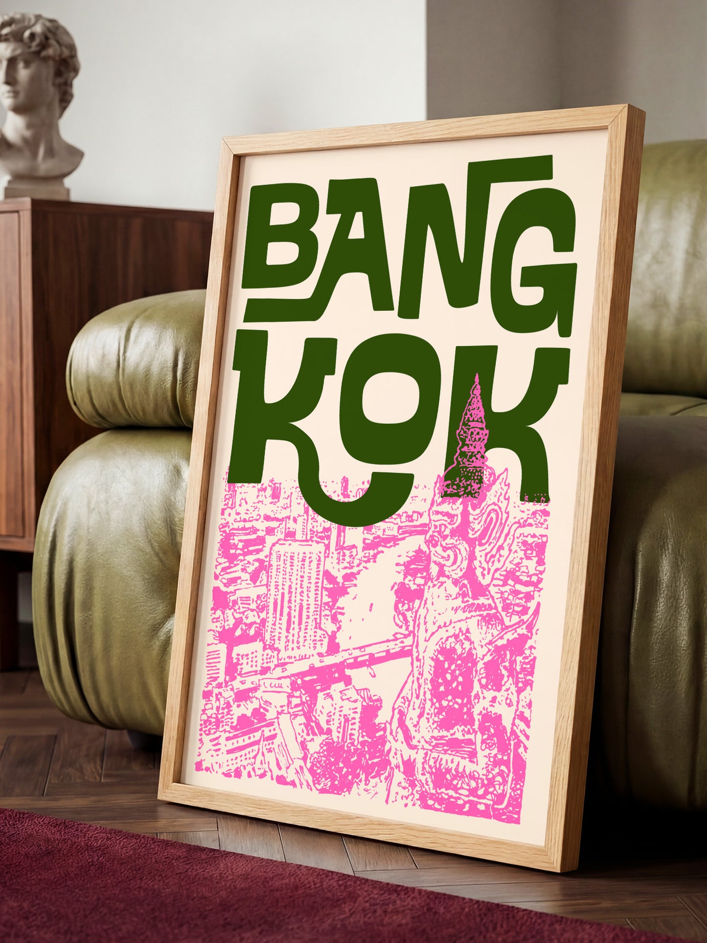 A framed poster with the text "BANG KOK" prominently displayed, featuring a pink and white illustration of a cityscape.