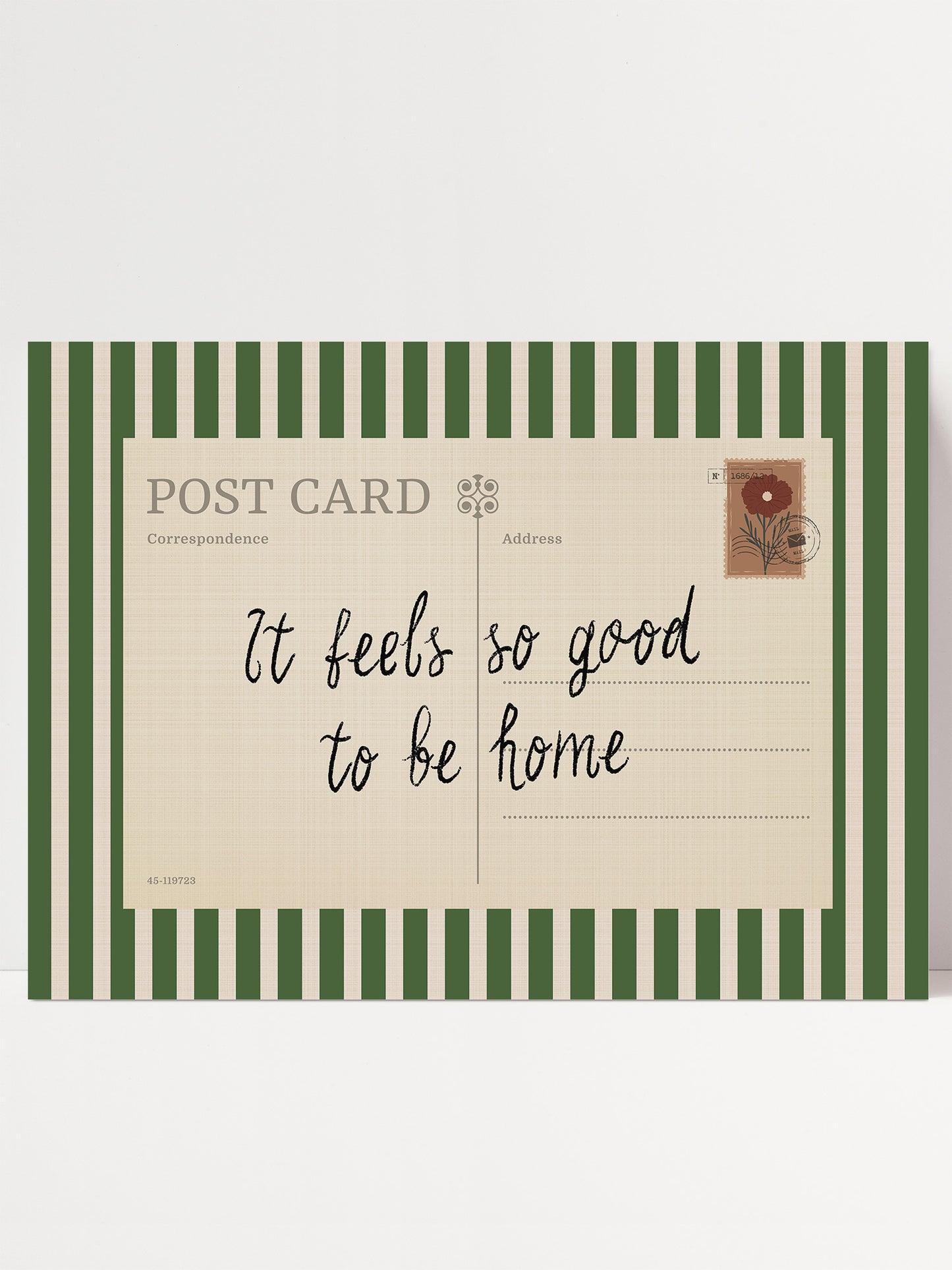 The image is a postcard with a green and white striped border. The postcard has a message that reads "It feels so good to be home" written in cursive.