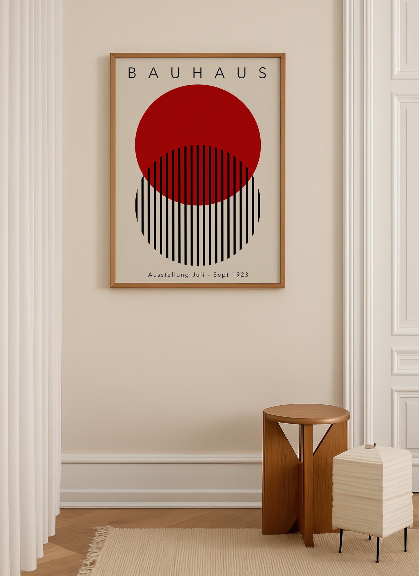 a minimalist art piece with a bold red circle and black stripes, hanging on a beige wall above a small wooden stool.