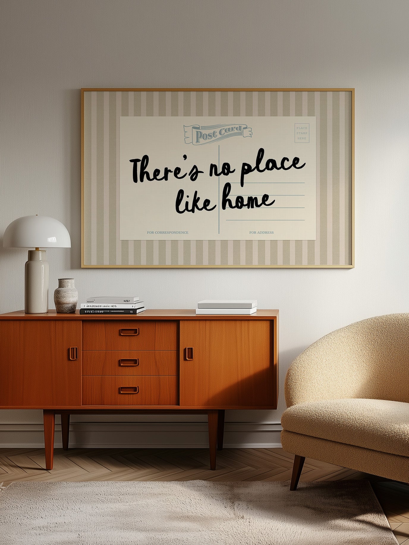 a vintage-style wooden cabinet with a lamp, a framed poster with the text "There's no place like home", and a beige armchair in a living room setting.