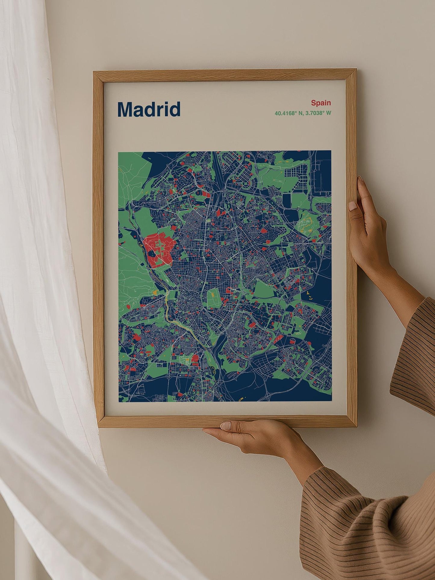 A person is holding a framed map of Madrid, Spain, which is a colorful and detailed representation of the city.