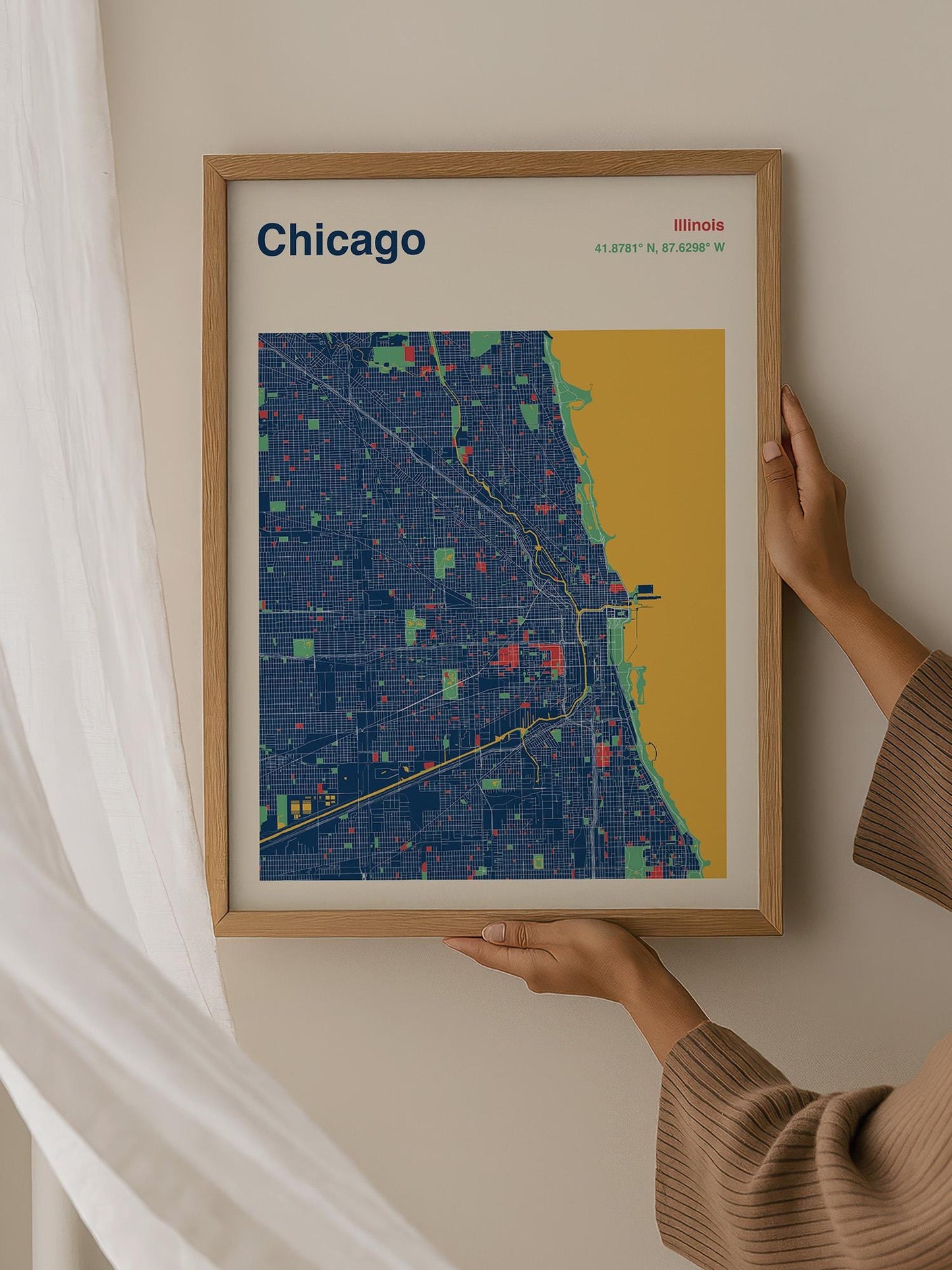A person is holding up a framed map of Chicago, Illinois, with the city's streets and neighborhoods clearly visible.