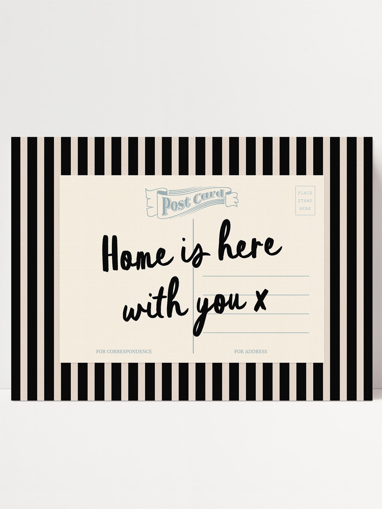 A postcard with a black and white striped border and text that reads "Home is here with you x".
