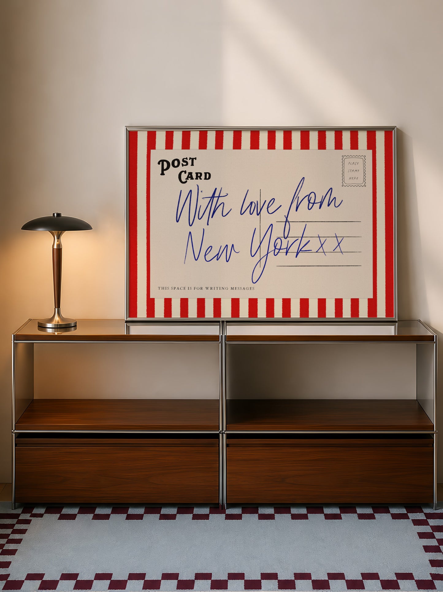 a wooden cabinet with a lamp on top, and a framed postcard with a handwritten message is displayed on the cabinet.