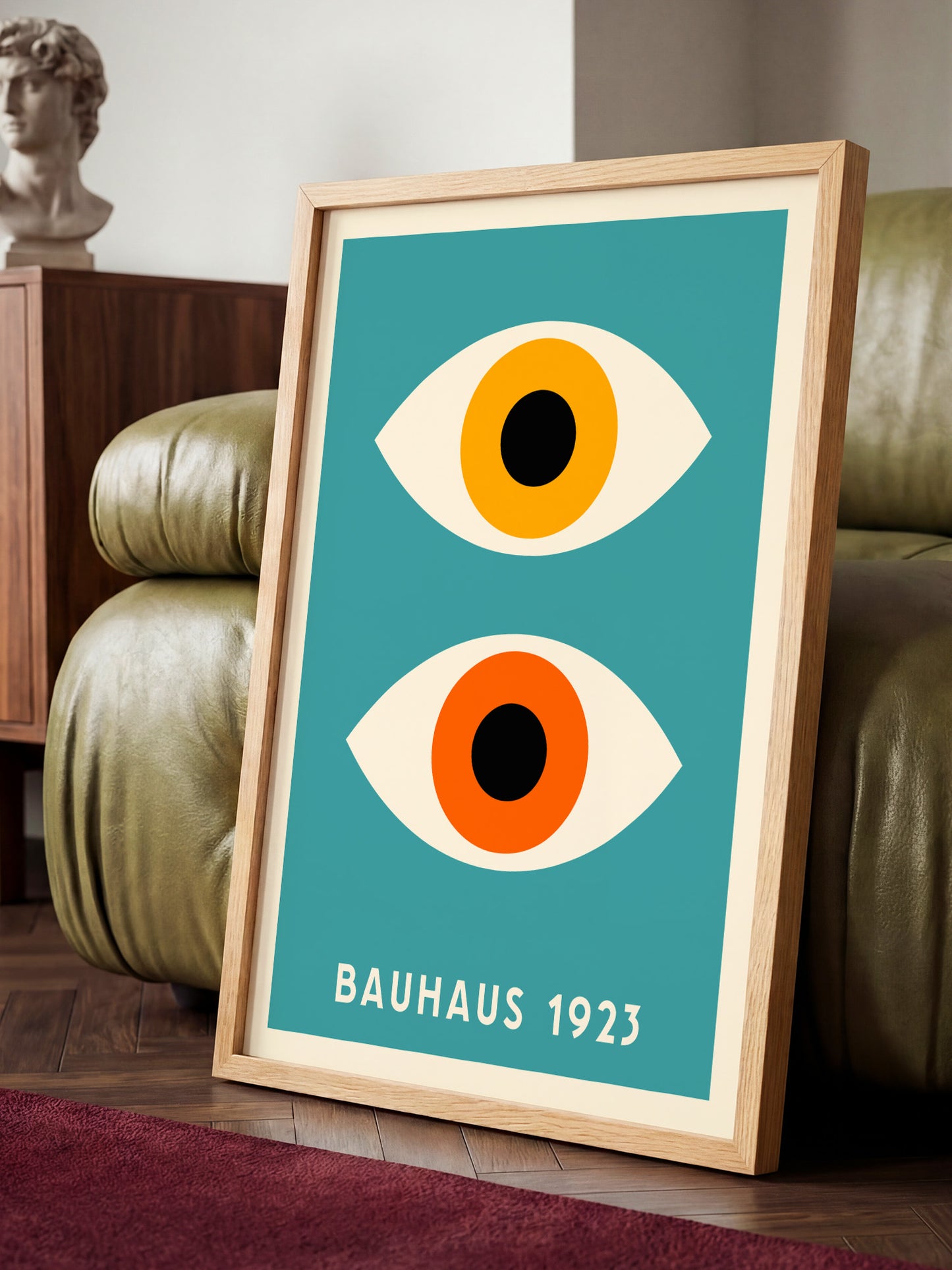 a framed poster of a stylized eye design with a teal background and a wooden frame.