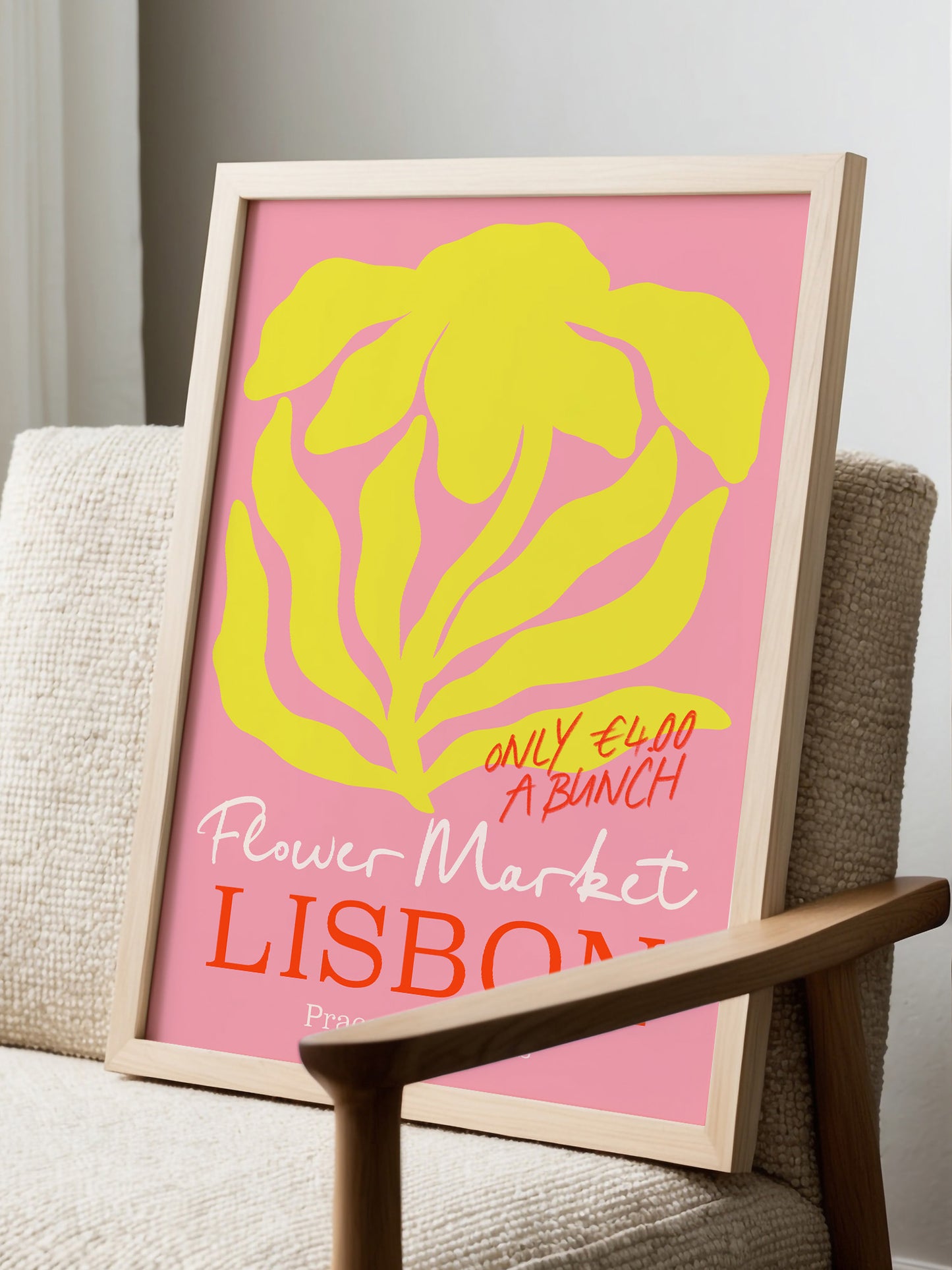 A framed poster advertising a flower market in Lisbon, Portugal, with a pink background and yellow flower design.