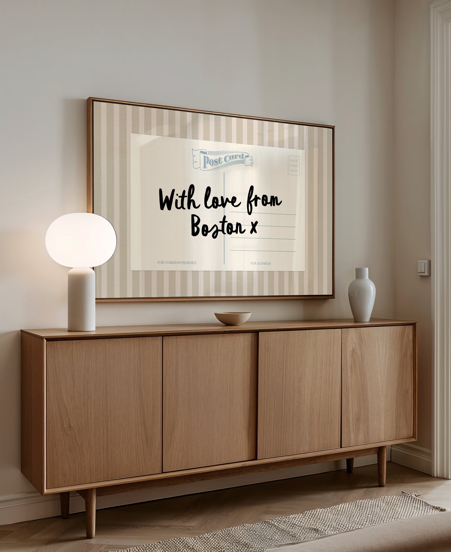 a wooden cabinet with a framed poster on the wall above it, which reads "With love from Boston x".