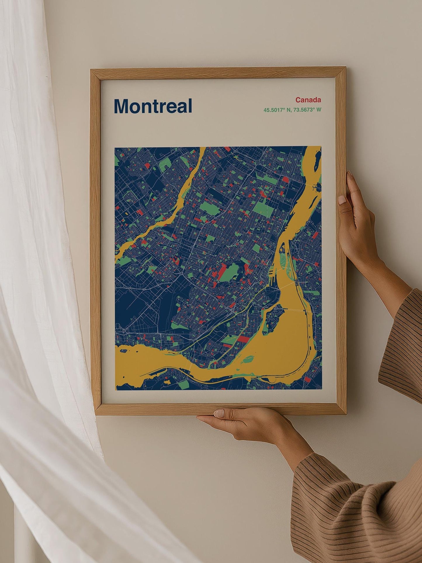 A person is holding up a framed map of Montreal, Canada, which features a colorful and detailed representation of the city.