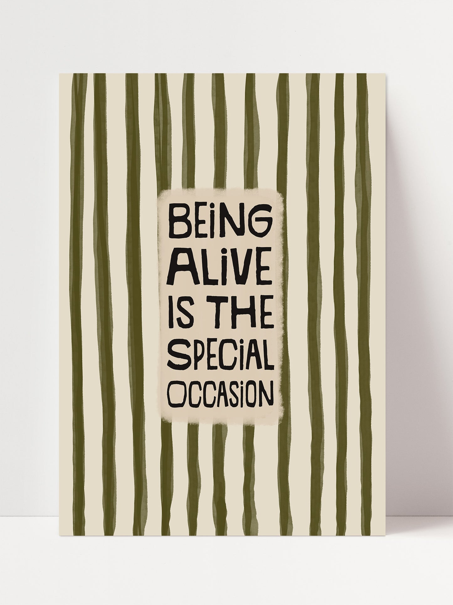 a bold statement in black text that reads "Being alive is the special occasion" against a background of vertical green and white stripes.