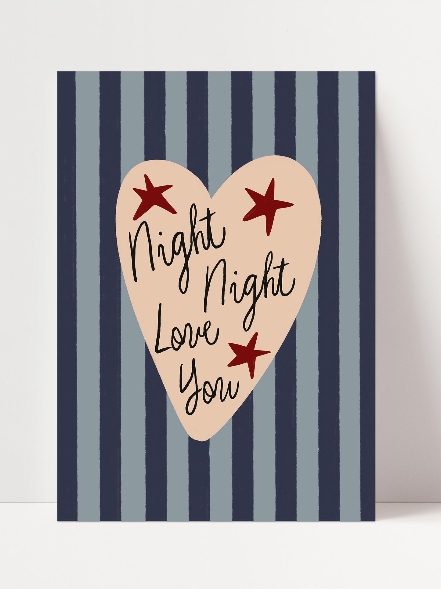 a heart-shaped design with the text "Night, Night, Love You" written inside it, surrounded by red stars against a background of blue and white striped vertical lines.